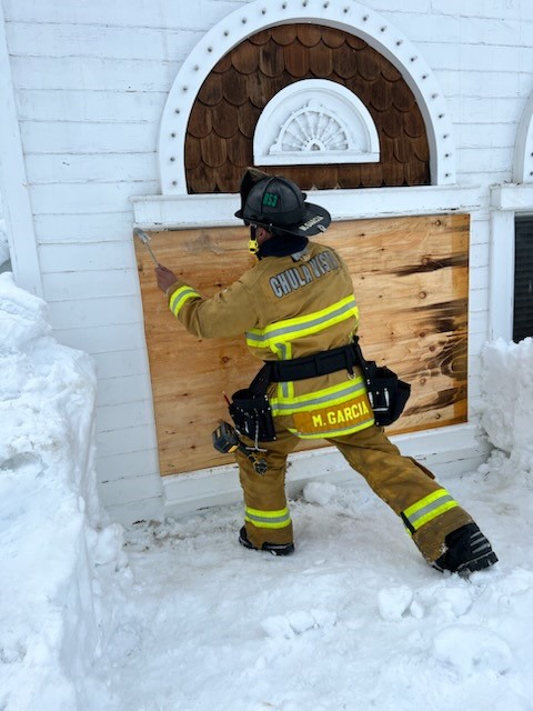 Winter Storm - firefighter fixing building