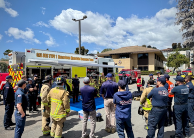 firefighters receiving a briefing outside of the hazmat vehicle.