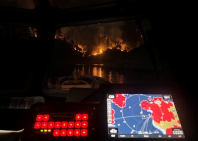 Image of fire on a hill from a boat with a control panel on the boat.
