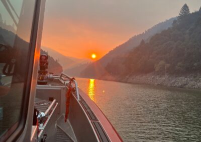 Smoke filled sunset on the lake from the view of a fire boat.