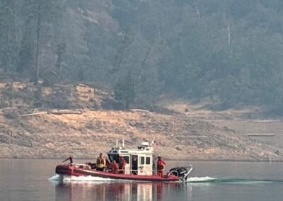 Fire boat with firefighters on a lake.
