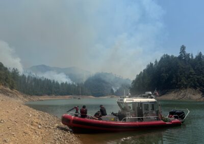 Fire boat on a lake with a smoke-filled sky.