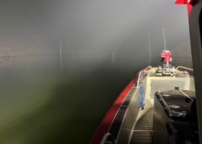 Fire boat on the lake at night with smoky air.