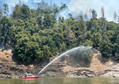 Fire boat on a lake engaging water suppression system.