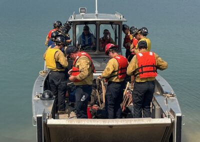 Firefighters on a boat on a lake.
