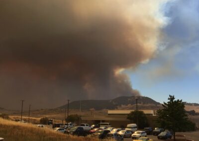 CalOES vehicle with wildfire smoke in the background.