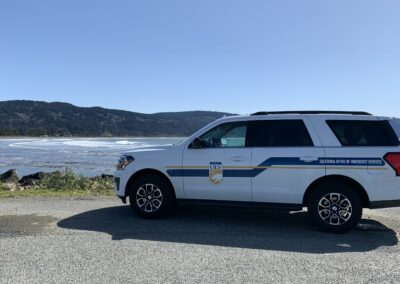 A CalOES vehicle parked in front of the ocean.